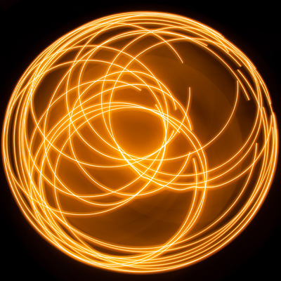 A square image of an orange light trail in circular and spiral forms.