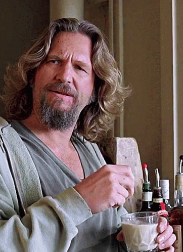 Lebowski stirs a white Russian while watching