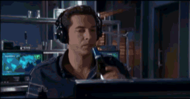 hacker typing with text flowing down a full screen while downing whiskey from the bottle